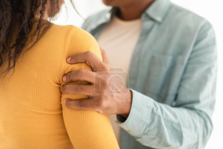 Photo for Aggressive angry young african american husband violently holds wife by shoulders, threatens and swears in room interior. Domestic violence, fear, relationship problems, quarrels at home due covid-19 - Royalty Free Image