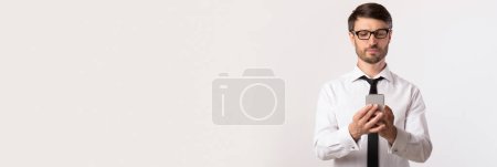 Photo for Business App. Wide Horizontal Banner With Young Businessman Using Modern Smarphone, Handsome Male Entrepreneur With Mobile Phone In Hands Posing Over White Background, Panorama With Copy Space - Royalty Free Image