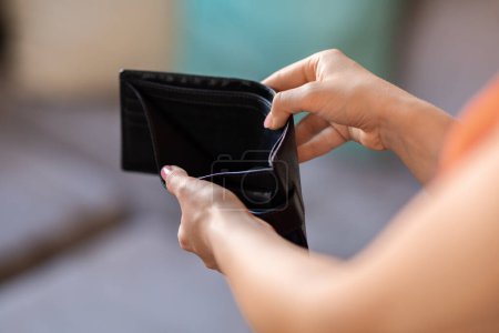 Closeup Shot Of Unrecognizable Female Holding Empty Wallet At Home, Young Woman Suffering From Poverty And Absence Of Money, Needy Lady Having Financial Crisis And No Savings, Cropped Image