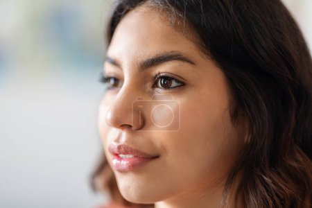 Photo for Closeup Shot Of Face Of Young Middle Eastern Woman Looking Away, Beauty Portrait Of Attractive Millennial Arab Female With Unaltered Skin And No Makeup Standing Indoors, Cropped Image - Royalty Free Image