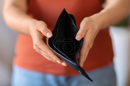 Photo for Poverty Concept. Cropped Shot Of Young Woman Showing Empty Wallet At Camera, Unrecognizable Female Suffering From Absence Of Money And Financial Crisis, Having No Savings, Standing Indoors - Royalty Free Image