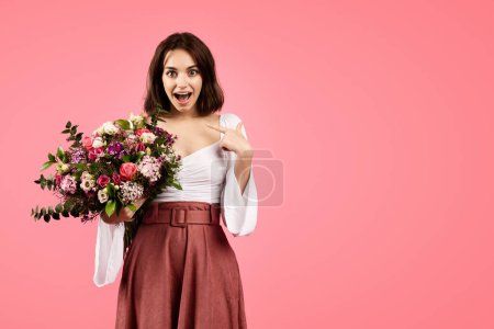 Photo for Glad young caucasian lady in casual with open mouth, show finger at herself, hold bouquet of flowers, rejoices gift, isolated on pink background, studio. Emotions from celebration of holiday in spring - Royalty Free Image