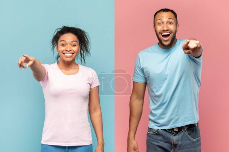 Téléchargez les photos : Hey, you. Joyful black couple pointing at camera, excited man and woman indicating somebody and having fun together while standing over pink and blue background - en image libre de droit