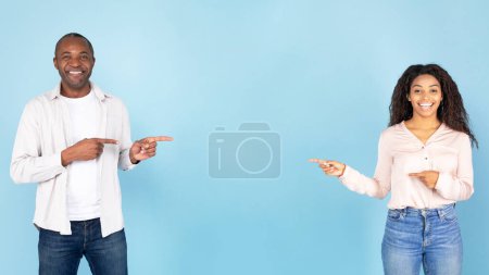 Photo for Best offer. Excited black couple pointing at copy space, middle aged man and young woman demonstrating free place for your advertisement, blue studio background, panorama - Royalty Free Image