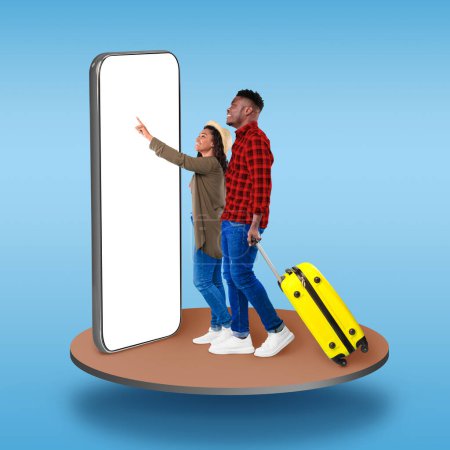 Téléchargez les photos : Stylish young man and woman with yellow suitcase tourists standing on pedestal over blue studio background, using big phone with white blank screen, booking hotel or flight online, mockup, collage - en image libre de droit