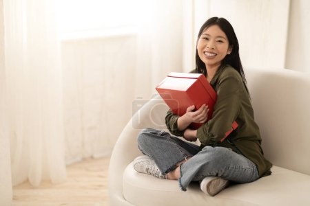 Photo for Overjoyed emotional young asian woman customer receive good parcel cardboard shoe box at home satisfied with great purchase, happy lady consumer hugging package postal shipping delivery, copy space - Royalty Free Image
