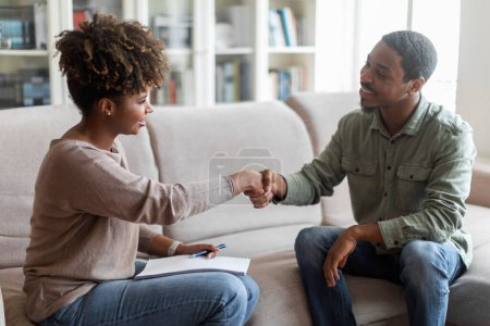Photo for Mental health, therapy, psychological assistance. Smiling happy cheerful millennial black guy shaking therapist attractive young woman hand, patient thankful for helpful session, copy space - Royalty Free Image