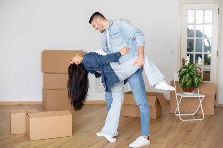 Téléchargez les photos : Happy Young Couple Dancing Together Among Unpacked Cardboard Boxes At Home, Romantic Spouses Making Dance In Their New Apartment, Celebrating Relocation To Own Flat, Full Length, Copy Space - en image libre de droit