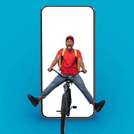 Téléchargez les photos : Fast Delivery App. Funny african american courier guy in red cap and uniform riding bicycle and wearing thermo backpack bag over big phone with blank sceen on blue studio background, mockup, collage - en image libre de droit