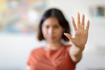 Téléchargez les photos : Young Arab Woman Showing Stop Gesture At Camera, Middle Eastern Millennial Female Demonstrating Open Palm While Standing At Home, Gesturing Sign Of Deny Or Refuse Domestic Violence, Selective Focus - en image libre de droit