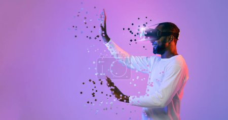 Photo for Black man in white using modern wireless VR headset touching something invisible with both hands on neon studio background and smiling, experiencing virtual reality, collage, copy space - Royalty Free Image
