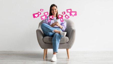 Photo for Happy young european female sit in armchair has romantic chat with hearts on smartphone, enjoys message on light background, studio, panorama, collage. App for dating remotely, relationships and love - Royalty Free Image