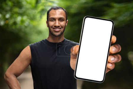 Photo for Fitness Tracker. Sporty African American Man Holding Big Blank Smartphone In Hand While Standing Outdoors, Athletic Black Male Recommending New Mobile Application For Workouts, Collage, Mockup - Royalty Free Image