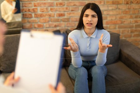Photo for Mental health and psychological assistance concept. Teen indian lady having counseling session with psychotherapist at clinic, talking and gesturing - Royalty Free Image