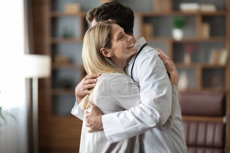 Photo for Doctor In Uniform And Female Patient Hugging During Meeting In Office, Happy Woman Thanking To Her Therapist After Successful Treatment And Recovery, Embracing Male Physician, Celebrating Good News - Royalty Free Image