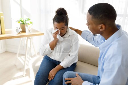 Photo for Attentive friendly young black man therapist supporting frustrated chubby millennial hispanic woman patient, mixed race obese lady attending therapy session, counselor office interior, copy space - Royalty Free Image