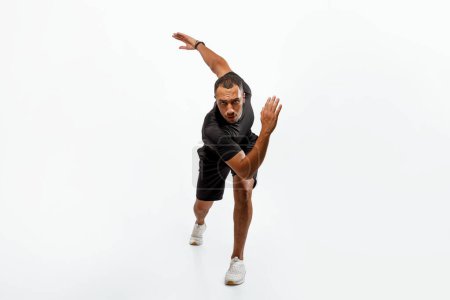 Photo for Male Workout. Sporty Black Guy Doing Forward Lunge Looking At Camera Exercising Over White Background In Studio, Wearing Fitwear. Fitness Training Concept. Full Length Shot - Royalty Free Image