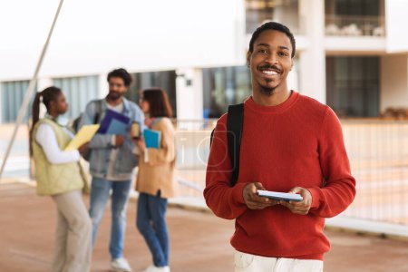 Photo for Happy young african american guy student with beard in casual with backpack, books studying at university with friends. Modern education, knowledge in college, break from lessons, lifestyle - Royalty Free Image