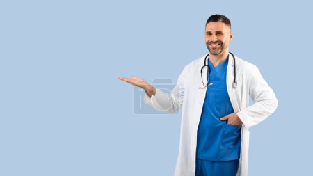 Photo for Medical offer. Happy male physician pointing aside and showing copy space with his open palm, demonstrating new pill or treatment, panorama, blue background - Royalty Free Image