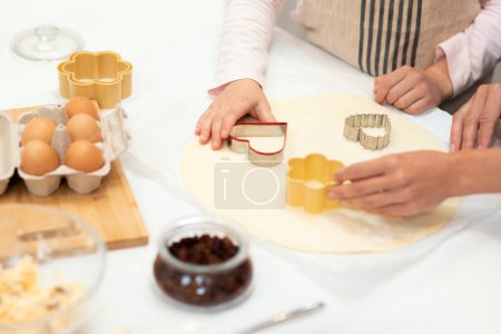 Photo for Hands of caucasian young mother and little daughter in aprons make cookie dough with forms on kitchen table with eggs. Lesson of homemade food, hobby, cooking sweets together at home - Royalty Free Image