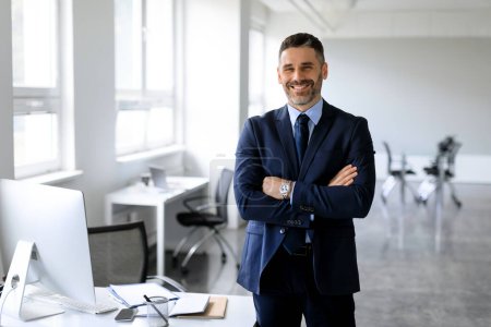 Photo for Successful business person. Portrait of male entrepreneur in suit standing in office, posing with folded hands smiling at camera, free copy space, empty mockup for advert - Royalty Free Image