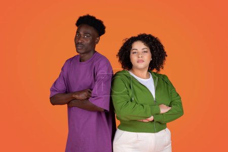 Photo for Break up, conflicts, quarrel, fight in relationships. Upset multiethnic young couple african american man and hispanic woman standing back to back, red studio background, copy space - Royalty Free Image