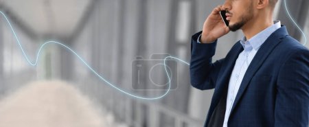 Téléchargez les photos : Sérieux jeune homme d'affaires arabe confiant en costume appel par smartphone à l'aéroport avec ligne abstraite, espace de copie, recadré, gros plan. Voyage d'affaires avec appareil, travail à distance, communication - en image libre de droit