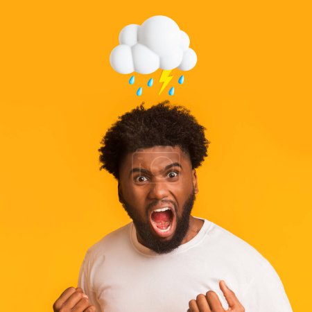 Téléchargez les photos : Angry millennial african american male scream with open mouth with abstract cloud of lightning, signe de pluie au-dessus de la tête sur fond de studio jaune. Mauvaise humeur, querelle, émotion négative et stress - en image libre de droit