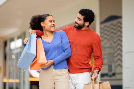 Photo for Family Weekend In Shopping Center. Happy Husband And Wife Posing With Paper Shopper Bags Having Fun During Sales Season Outdoor. Couple Buying New Clothes Together. Discount Offer Concept - Royalty Free Image