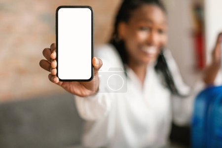 Foto de Turista mostrando teléfono inteligente en blanco, viajera negra recomendando aplicación móvil para reservar boletos en línea, enfoque selectivo, maqueta - Imagen libre de derechos