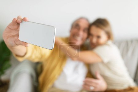 Téléchargez les photos : Couple âgé passe du temps, s'amuser et prendre selfie sur smartphone, conjoints profiter de divertissements en ligne, se concentrer sur le téléphone. Ancienne génération et concept technologique moderne - en image libre de droit