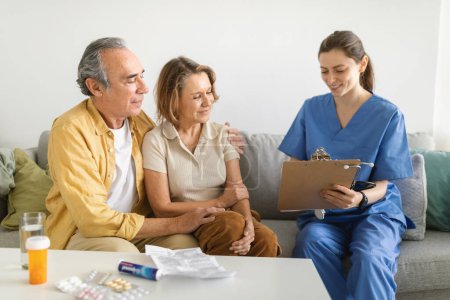 Photo for Nurse during home visit with senior couple, doctor holding clipboard in conversation with old man and woman. Nurse bringing home the results of medical exams - Royalty Free Image