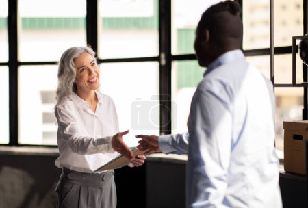 Photo for Headhunting. Cheerful HR Manager Woman Shaking Hands With Male Job Applicant In Modern Office. Successful Business Meeting And Job Interview Concept. Selective Focus On Businesswoman - Royalty Free Image