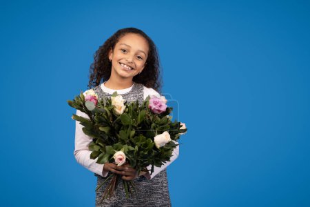 Photo for Greeting birthday. Smiling african american little girl with bouquet of flowers isolated on blue background, studio. Holiday celebration, congratulation, children emotions and childhood - Royalty Free Image
