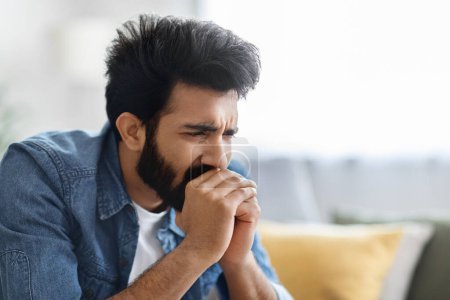 Photo for Permacrisis Concept. Portrait Of Stressed Young Indian Man Sitting On Couch At Home, Closeup Shot Of Worried Millennial Eastern Male Thinking About Life Problems, Feeling Anxious, Copy Space - Royalty Free Image