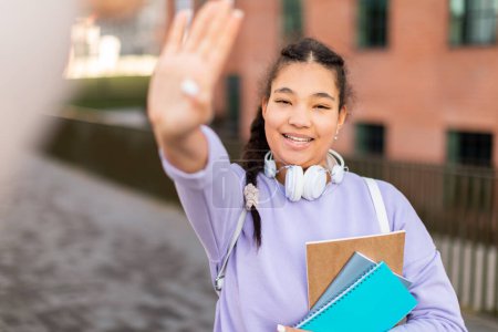 Photo for Happy mixed race student girl giving high five celebrating academic success and passed exam, standing in college campus outdoors. Successful studentship concept - Royalty Free Image