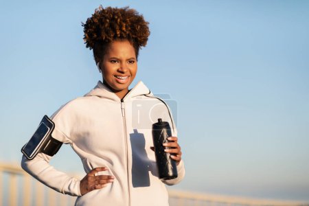 Photo for Black Female Athlete Holding Fitness Bottle While Standing Outdoors After Sport Workout, Motivated Young African American Woman In Sportswear Drinking Water After Jogging Outside, Copy Space - Royalty Free Image