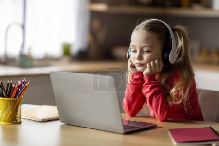 Photo for E-Learning Problems. Bored Little Girl In Wireless Headphones Looking At Laptop Screen, Upset Preteen Female Child Study With Computer At Home, Doing Homework, Having Remote Education Issues - Royalty Free Image