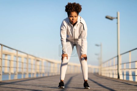 Photo for Portrait Of Tired Young Black Female Athlete Resting After Jogging Outdoors, Motivated African American Woman In Sportswear Catching Breath And Leaning On Knees, Taking Break During Morning Run - Royalty Free Image
