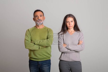 Photo for Sad strict dissatisfied serious confident caucasian elderly couple with crossed arms on chest on gray studio background. Bad offer, stress, relationship problems, quarrel and negative - Royalty Free Image