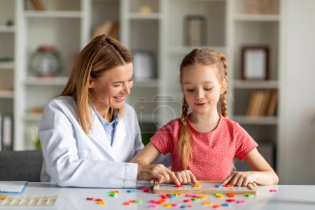 Photo for Child Development Specialist Working With Cute Little Girl During Lesson, Therapist Woman Using Fun Interactive Games To Improve Kids Language, Happy Child Playing With Colorful Letters On Table - Royalty Free Image