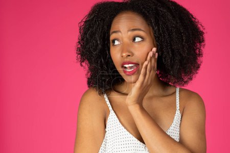 Photo for Portrait of glad pensive surprised millennial african american curly lady looking at empty space isolated on pink background, studio, close up. Huge sale, great news, offer and ad - Royalty Free Image