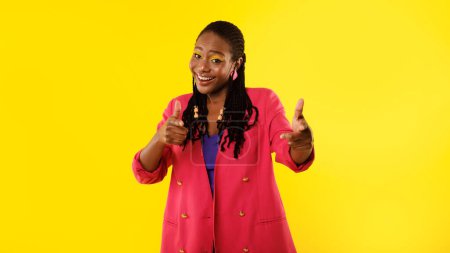 Photo for You Are Next. Positive Black Lady With Bright Makeup Pointing Fingers Towards Camera Standing Posing In Studio Over Yellow Background. I Choose You Concept. Panoramic Shot - Royalty Free Image