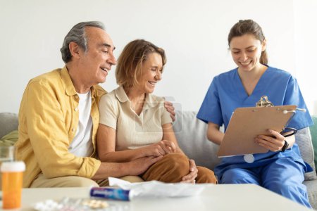 Photo for Visit to patient. Nurse talking with senior couple, holding clipboard in conversation with aged man and woman, bringing home the results of medical exams - Royalty Free Image