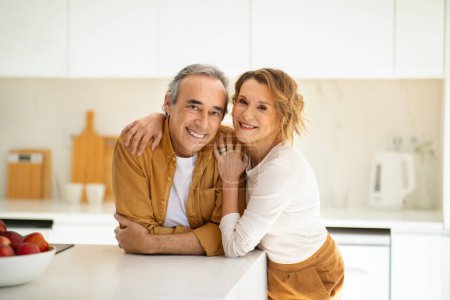 Téléchargez les photos : Portrait de conjoints mariés âgés heureux posant et embrassant dans la cuisine, couple âgé regardant et souriant à la caméra, appréciant passer du temps ensemble à la maison, espace de copie - en image libre de droit
