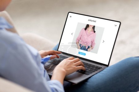 Photo for Young european woman sit on couch at home, using modern laptop for surfing in internet, enjoy online shopping, with fashion website store on screen, cropped. Shopaholic order clothes at home - Royalty Free Image