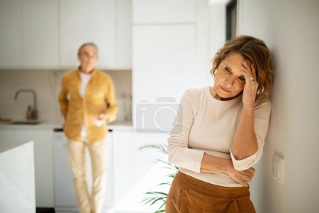 Téléchargez les photos : Couple caucasien âgé bouleversé debout dans la cuisine après dispute, homme et femme âgés ayant des conflits domestiques, souffrant crise relationnelle, accent sélectif sur dame pleure âgée - en image libre de droit