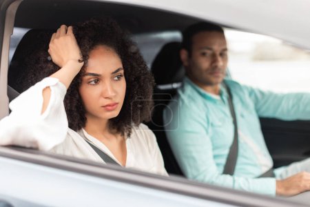 Photo for Driving Disagreements. Displeased Middle Eastern Wife Expressing Unhappiness Towards Husband During Car Ride Sitting On Passengers Seat Inside. Family Conflicts Concept. Selective Focus - Royalty Free Image