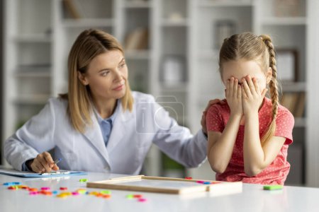Photo for Kids Psychological Problems. Upset little girl crying during therapy session with psychologist woman, covering face with both hands, psychotherapist lady comforting sad kid, closeup - Royalty Free Image