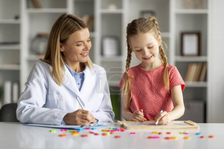 Photo for Professional Child Psychologist Lady Having Therapy Session With Cute Little Girl, Smiling Preteen Female Kid Sitting At Table And Painting On Drawing Board, Enjoying Development Games And Activities - Royalty Free Image
